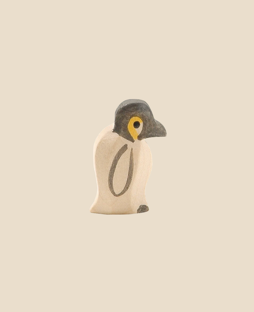 The Ostheimer Penguin, Small is a minimalist wooden figurine featuring a black head and white body. This handcrafted toy stands alone against a beige background, characterized by its simplicity and modern aesthetic. With minimal details, it offers a clean design that’s perfect for imaginative play.