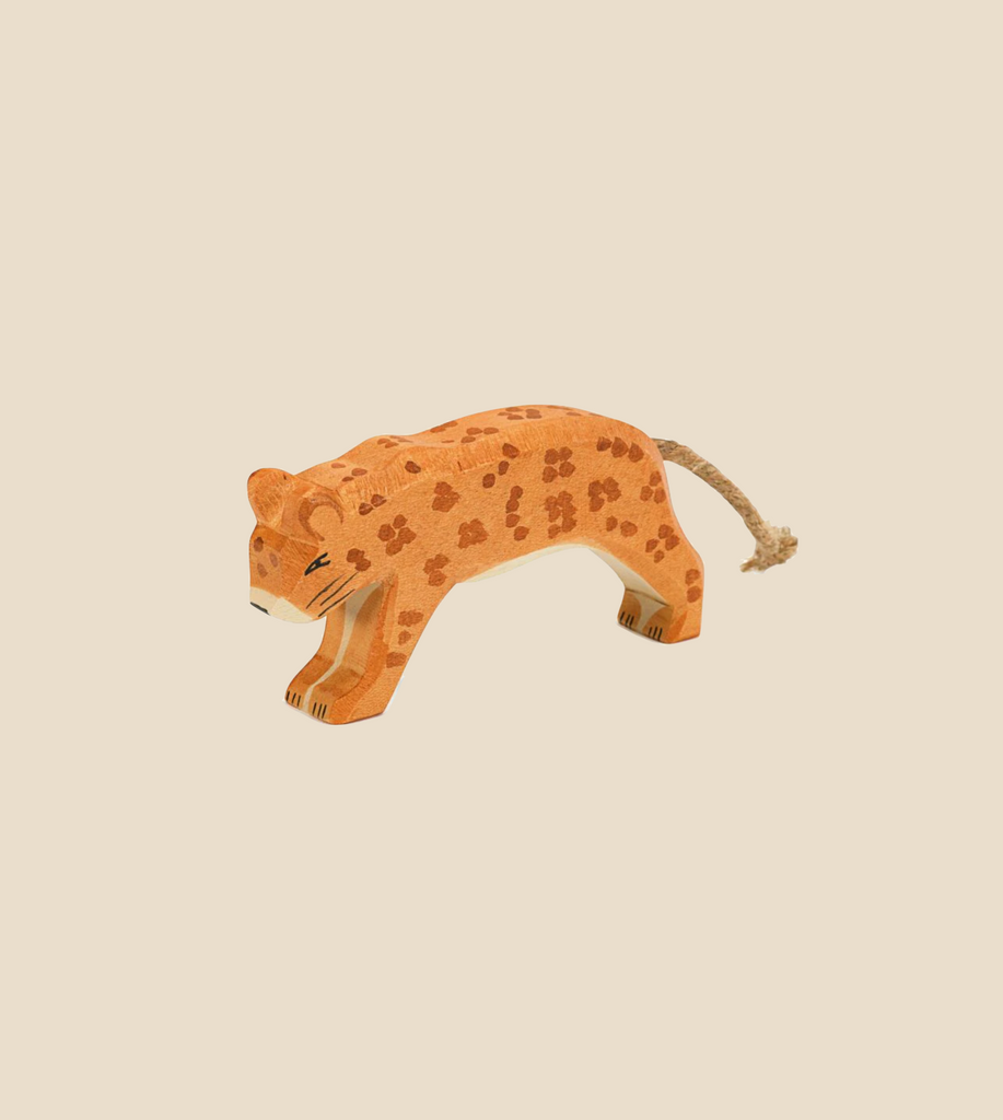 The Ostheimer Leopard is a small, handcrafted wooden figure that features painted spots and is depicted in a walking pose against a beige background. Reminiscent of Ostheimer's style, this figure boasts a simple, minimalist design that emphasizes the natural wood texture and muted colors, making it perfect for imaginative play.