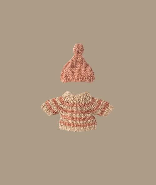 The Maileg Knitted Sweater and Hat for Big Sister Mouse, an ideal choice for wintertime attire, are showcased on a light beige background. The hat is pink, and the sweater displays horizontal pink and beige stripes. Both items are neatly centered.