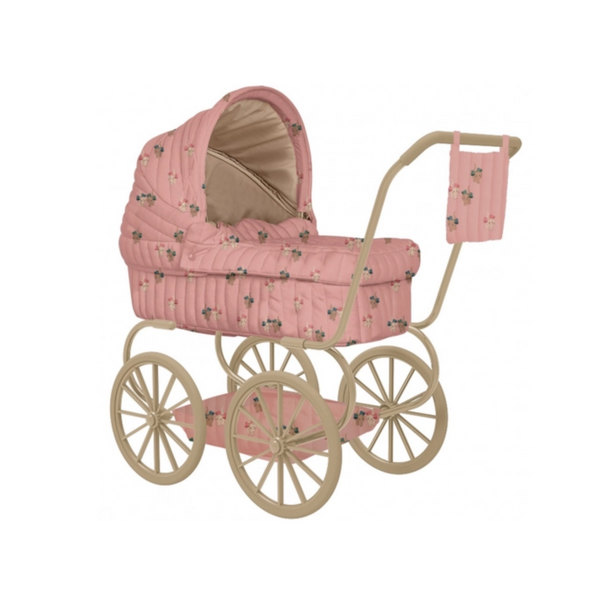 The Konges Sloejd Mini Doll Pram - Kitty Bow features a pink vintage-style design with floral patterns, beige interior, and wheels. It includes a cushioned storage basket and a matching floral fabric bag on the handlebar.