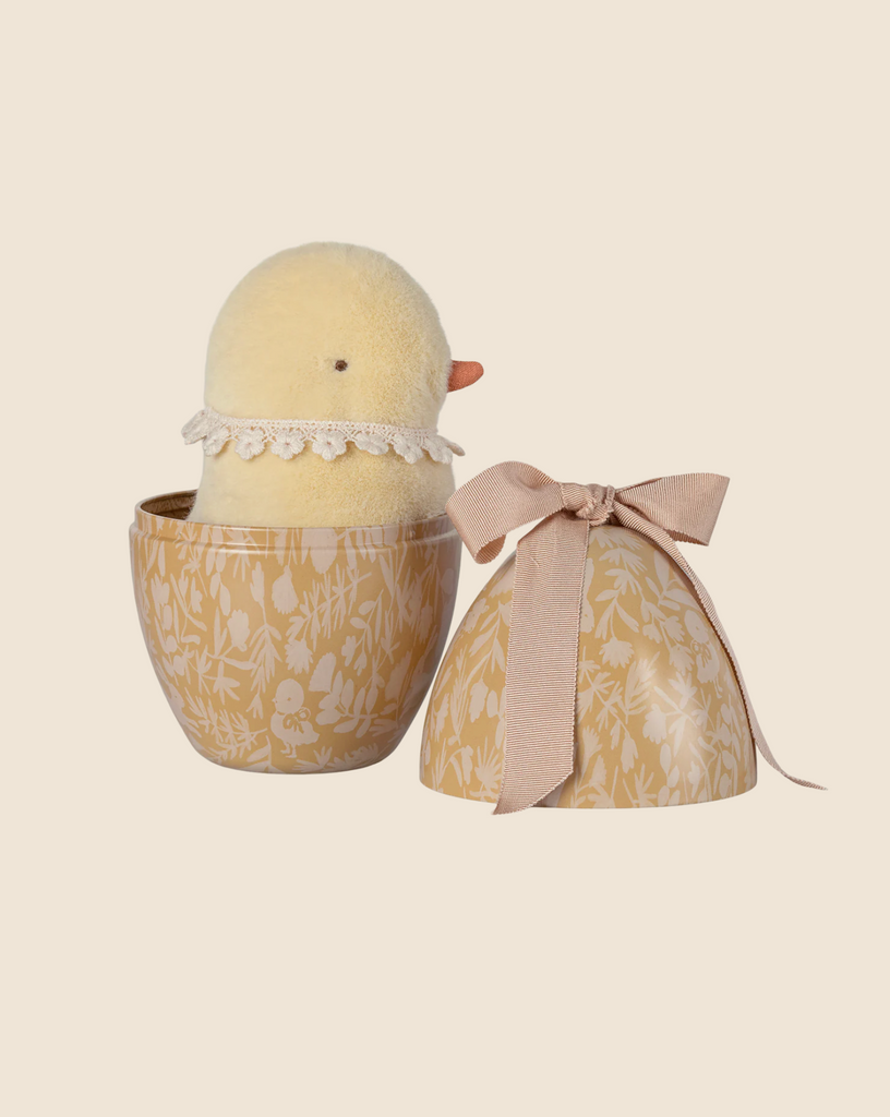 The PRE-ORDER: Maileg Easter Egg With Chick (Ships in February) features a plush yellow chick made of recycled polyester, wearing a lace collar. It's tucked inside a decorative floral egg with a pink bow, resting against a beige background, perfect for all ages to cherish and enjoy.