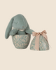 The PRE-ORDER: Maileg Easter Egg With Bunny - Mint (Shipping in February) features a plush bunny filled with recycled polyester and PE pellets, tucked inside a floral-designed egg-shaped container. A ribbon bow adorns the metallic-accented lid, resting against a soft beige background.