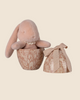 The PRE-ORDER: Maileg Easter Egg With Bunny - Powder features a plush bunny made from recycled polyester inside a brown floral-patterned, egg-shaped container with an open lid and ribbon bow. Ships in February.