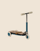 The Maileg Mouse Size Scooter features a vintage-style blue three-wheeled frame, wooden deck, white wheels, and beige handles. It stands against a plain beige background and ships in approximately one week.