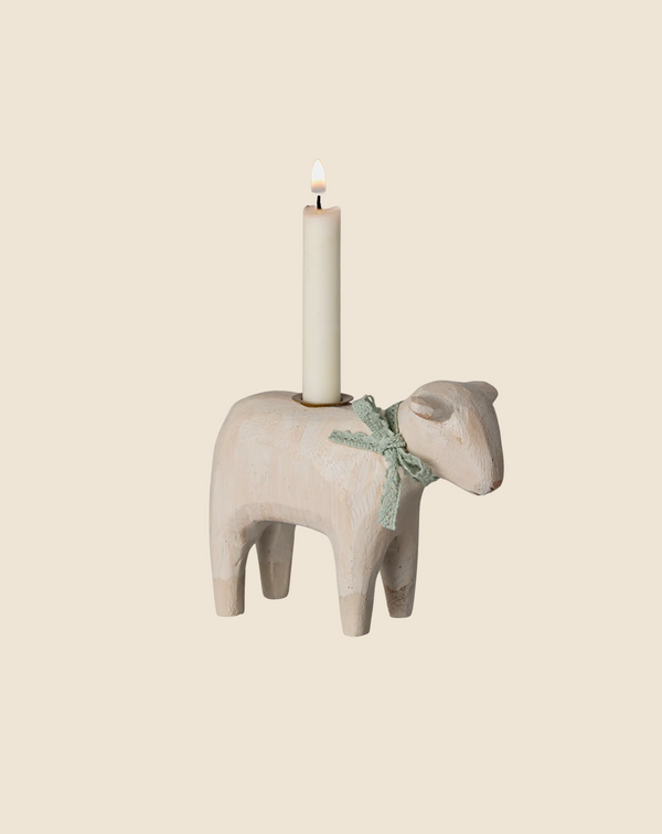 The PRE-ORDER Maileg Wooden Candle holder—a handmade, mint-finished lamb—displays a single lit, white candle. With a green ribbon around its neck, this charming piece enhances your Easter table against a beige background. Ships late January.