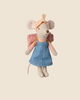 The Maileg Hiker Mouse, part of the hiker collection, features a pink headband, blue dress, plaid shirt, floppy ears, long tail, and a pink backpack against a beige backdrop. Available for pre-order with a blush sleeping bag - Big Sister (ships in February).