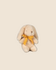 The Maileg Plush Bunny - Mini Cream is a beige toy sitting against a cream background. It features long ears and soft plush made from recycled polyester, complemented by a yellow bow around its neck. Pre-order now for February shipping.