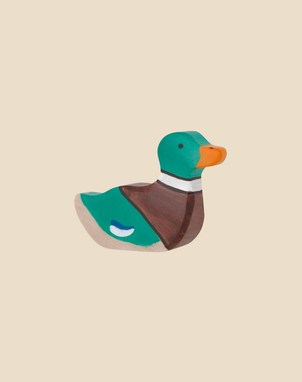 The Holztiger Mallard Duck, Sitting is a handcrafted wooden figurine featuring a green head, orange beak, brown chest, and blue-white wing spot. Ships in one week. Shown on a plain beige background.