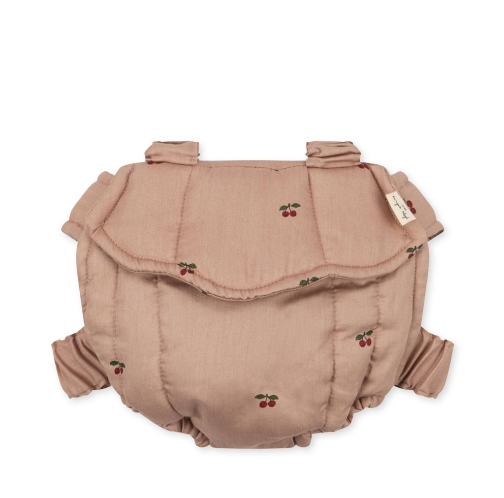 The Konges Sloejd Doll Carrier - Cherry Blush features a soft, light pink design with red cherry prints, elastic leg openings, a fold-over flap, and two fabric loops—ideal for pairing with your child's favorite dolls.
