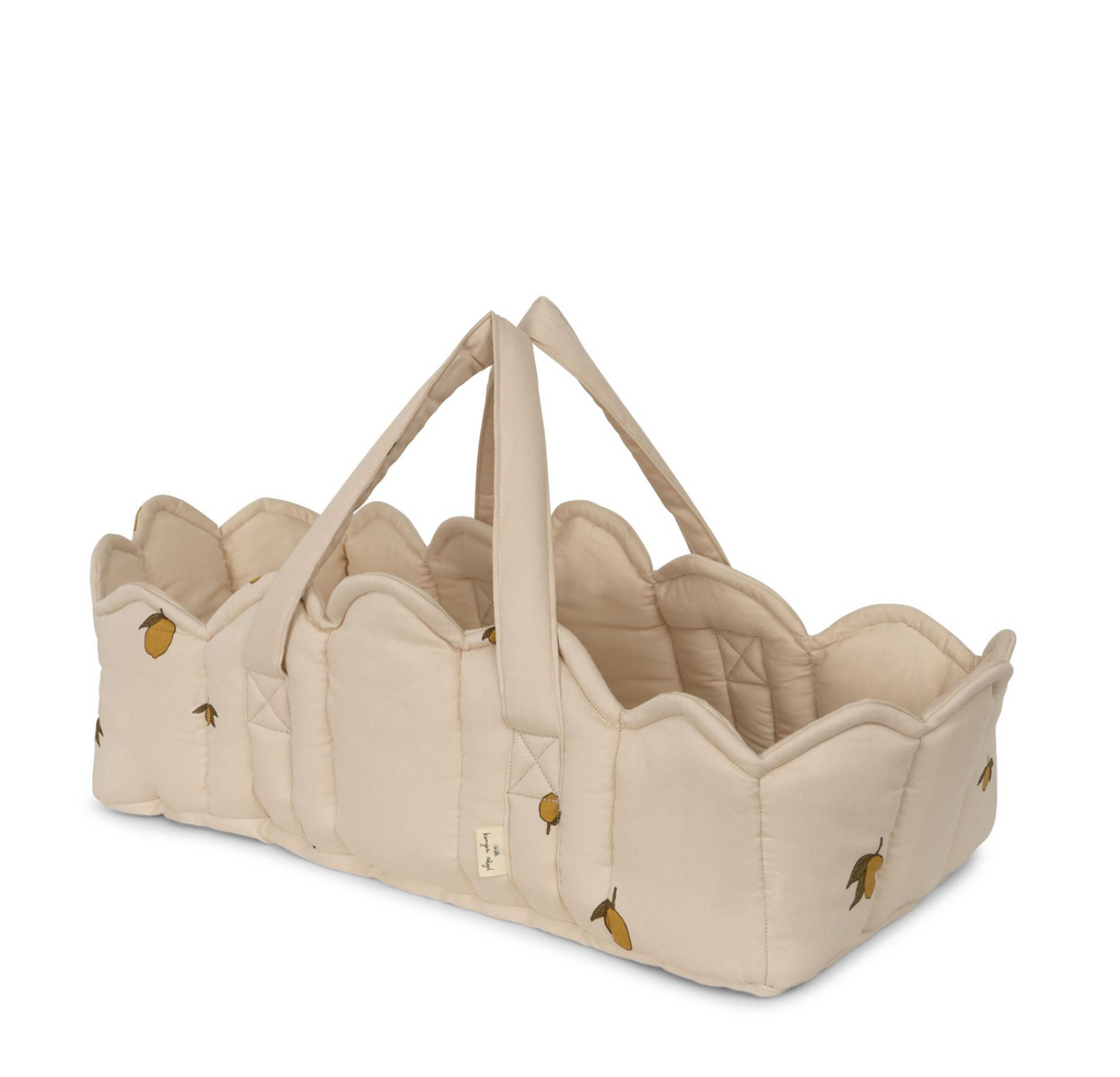 The Konges Sloejd Doll Lift - Lemon is a beige quilted basket with scalloped edges, two OEKO-TEX certified carry straps, and a charming small yellow lemon and green leaf pattern.