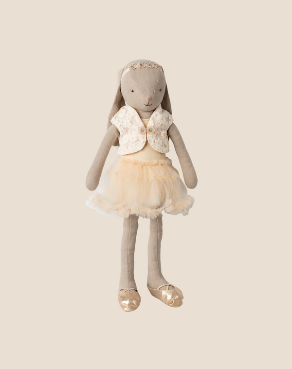 The Maileg Bunny, Size 3 - Classic, wears a cream ballet suit and skirt with matching accessories, standing upright against a beige background ready to dance.