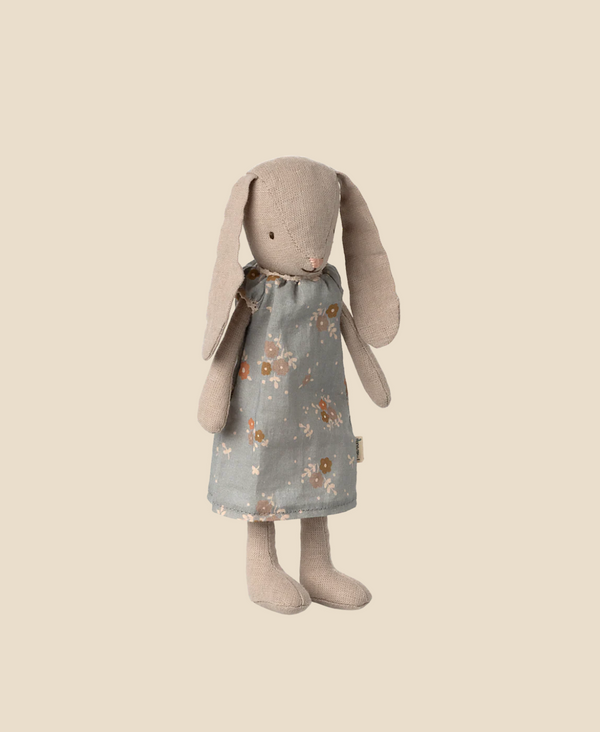 The Maileg Bunny, Size 1 - Classic - Dress is a beige stuffed toy with long floppy ears, made from soft natural fabrics and dressed in a blue floral dress, standing upright against a plain light background.
