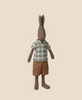 The Maileg Rabbit, Size 3 - Brown, is dressed in a plaid shirt and brown shorts, standing upright against a beige background, highlighting its charming outfit made from soft natural fabrics.
