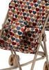 A close-up of the Konges Sloejd Doll Stroller - Heart Kisses shows its tan frame, double wheels, and armrests, with a fabric seat featuring a colorful heart pattern in red, blue, beige, and brown. The carriage bag is also partly visible.