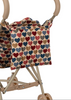 A close-up of the Konges Sloejd Doll Stroller - Heart Kisses, featuring double wheels and a fabric carriage bag with a multicolored heart pattern in blue, red, and beige tones, matching its beige frame.