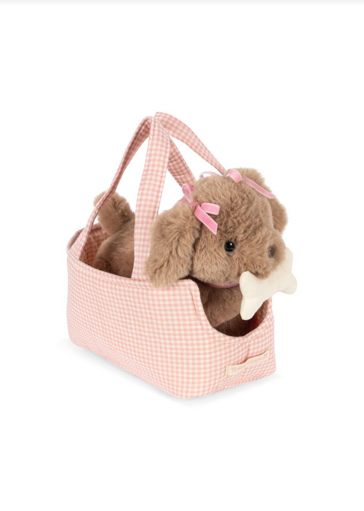 The Konges Sloejd Maude Puppy in Basket features a soft puppy toy with pink bows and a white bone, nestled inside a pink-and-white checkered handled dog basket.