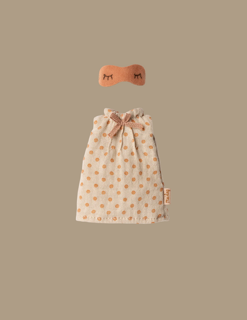 A small beige Maileg Extra Clothing: Nightgown For Mom Mouse, with orange polka dots and a bow at the neck, plus a matching orange nightgown-style eye mask with embroidered closed eyes, displayed on a plain beige background.