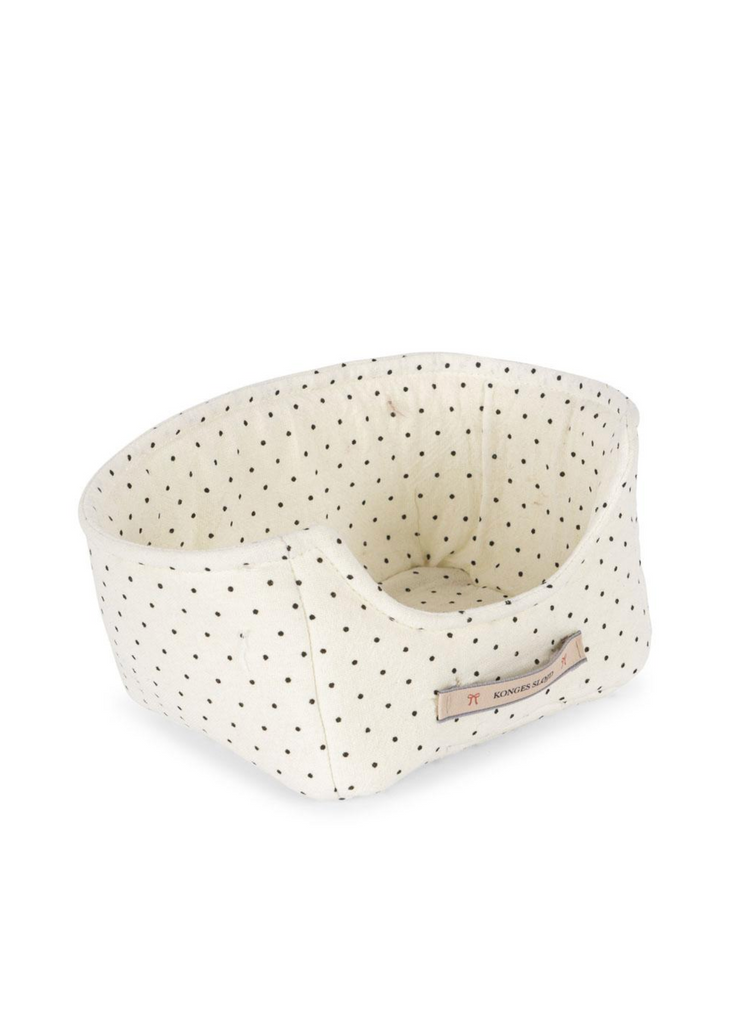 The Konges Sloejd Bunnys in Basket Set features a cream oval padded bed with raised sides and black polka dots, plus a stitched front label. Its soft fabric is ideal for little bunnies to snuggle comfortably.