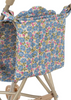 A close-up of the Konges Sloejd Doll Stroller - Rose Flower shows a removable storage bag with blue and pink flowers and green leaves on white, attached to a beige metal frame.