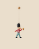 The Maileg Metal Ornament, Guard - Trumpet features a marching toy soldier in a red coat and blue pants playing a golden trumpet—a charming holiday decoration for your Christmas tree.