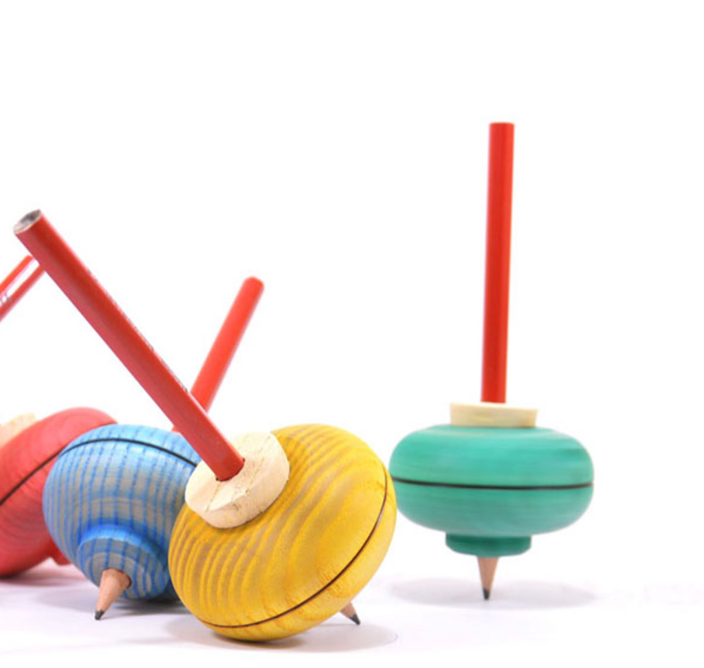 A Mader Malkreisel Drawing Top in green, featuring a red stick handle, pointed tip, and visible wood grain, stands on a white surface—this classic wooden toy is beautifully painted for timeless play.