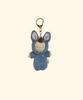 The Olli Ella Cozy Bag Charm - Bunny Twiggy is a plush bag charm featuring a small doll in a blue bunny costume with large ears, closed eyes, and a peaceful expression, attached to a gold keyring on a plain beige background.