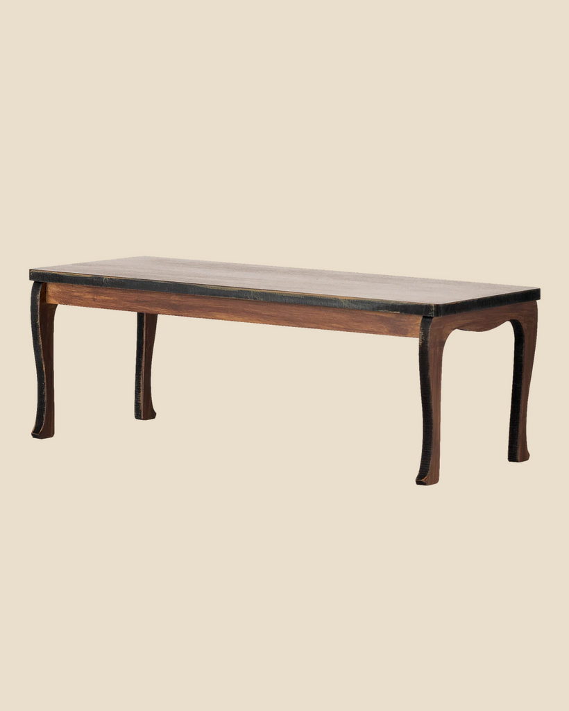 The Maileg Long Dining Table, Mouse (expected arrival: 03/15/26), features a rectangular wooden design with a dark finish and curved legs, perfect as a mouse table or for charming dollhouse accessories on a plain beige background.