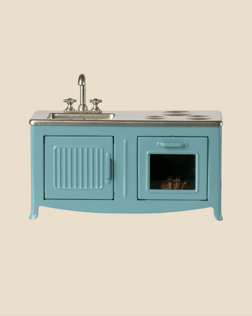 The Maileg Kitchen, Mouse - Blue (expected arrival: 04/01/26) is a small toy kitchen with a sink, faucet, stovetop, and oven with window and baking tray—ideal for a mouse family. Set against a plain beige background.