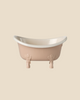 The Maileg Bathroom Set features a small, light-pink bathtub with a white interior and four animal paw feet, displayed against a plain beige background. This tub is part of the Maileg mouse furniture collection.