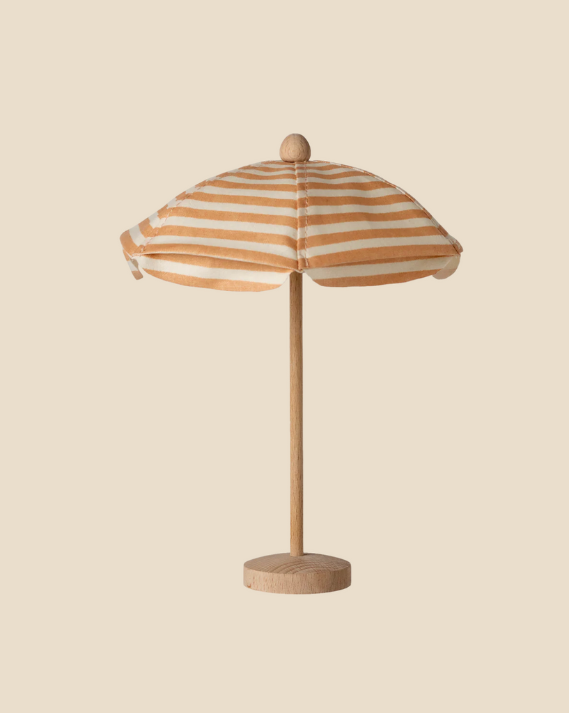 Pre-order the Maileg Beach Umbrella, Mouse - Soft Coral (expected 03/15/26), a small wooden model with a round base and orange-white striped fabric canopy for your mouse family, set against a beige background.
