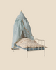 The Pre-order: Maileg Bed Canopy, Miniature - Mint is shown on a small toy metal bed with a blue-striped mattress and floral blanket. A stuffed rabbit sits tucked in, making it a charming bedroom decor piece. Expected arrival by 04/15/26.