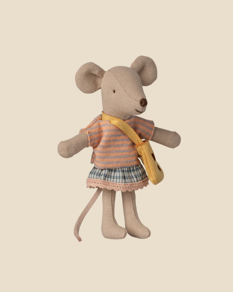 Pre-order the Maileg Little Sister Mouse with Bag, arriving by 06/15/26. This stuffed toy features a pink and gray striped top, plaid skirt, and yellow cheese bag, posed upright against a plain beige background.