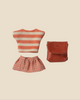 Pre-order: Maileg Clothes and Bag, Big Sister Mouse - Coral. Includes a striped top, pink plaid skirt, and small red faux-leather bag—ideal mouse accessories. Expected arrival by 05/01/26. Displayed on a light beige background.
