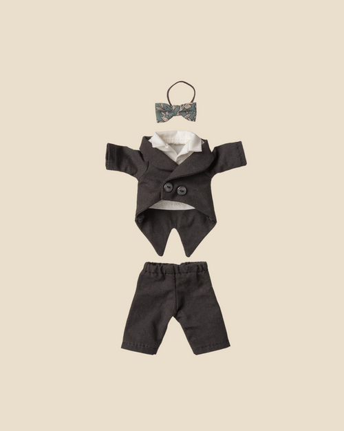 The Pre-order: Maileg Wedding Suit, Dad Mouse (Expected arrival by 06/15/26) is a small formal black outfit with jacket, pants, and a floral-patterned bow tie, displayed neatly on a beige background.