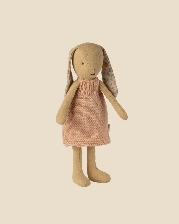 Pre-order the Maileg Bunny, Size 1 in Cream Yellow, dressed in a pink knitted dress. This soft linen toy features long floral-patterned ears and stands upright. Expected arrival: 02/15/26.