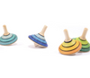 Four Mader Small Tango Spinning Tops in yellow maple wood, striped with blue, turquoise, and green, are arranged on a white background—two upright and two leaning or spinning—all crafted to meet toy safety standards.