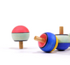 Three Mader Confetti Turn-Over Spinning Tops in bright blue, yellow, green, red, and white hues—classic wooden toys with smooth stems; one spins upright while two rest on their sides.