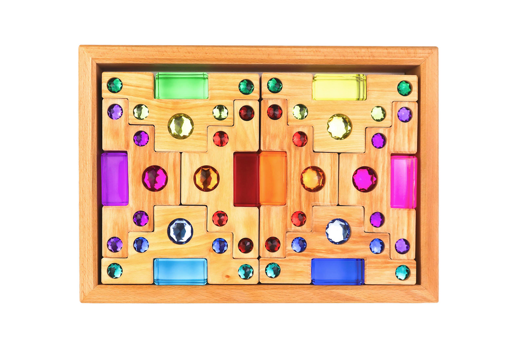 The Bauspiel Colored Staircase with Luminous Blocks – 32 Piece includes wooden blocks in rectangular and square shapes, each set with vibrant gem-like accents, arranged in a symmetrical tray—ideal for creative play or building sets.