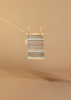 A small rectangular rug with beige, brown, and blue stripes hangs from a clothesline with wooden clothespins—an ideal cozy accent for your Maileg Fully Furnished SuitCasa or to pair with the matching kitchen counter.