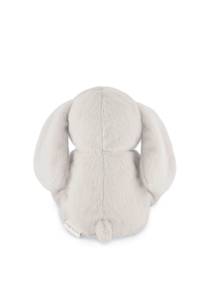A plush, light gray stuffed animal named Snuggle Bunnies - Olive The Elephant is shown from the back with long floppy ears, a small round tail, a fuzzy texture, and a white tag near the tail.