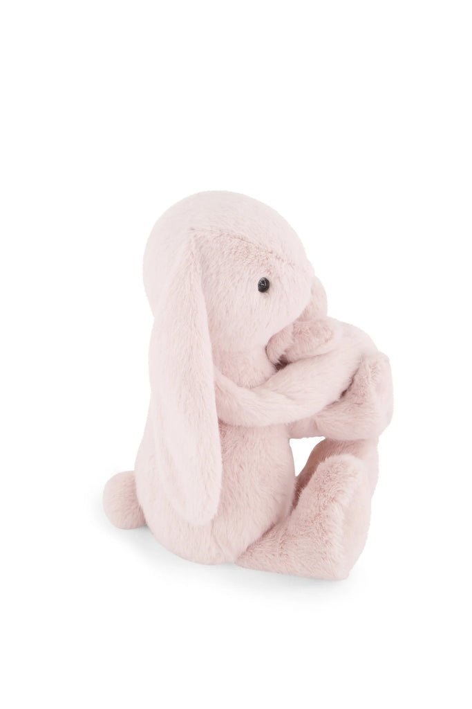 Snuggle Bunnies - Frankie the Hugging Bunny - Blossom is a super soft, light pink plush bunny with floppy ears and a round tail, sitting upright and holding its feet on a plain white background.