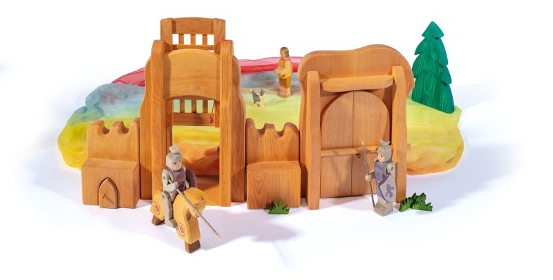 Ostheimer wooden toys present the Yellow Horse for Knight, a beautifully handcrafted addition to their collection. This enchanting set includes a knight on horseback, accompanied by features such as a castle gate, archway, and an intricate fabric landscape with trees. Background figures further enrich the scene, providing depth and limitless imaginative play opportunities.