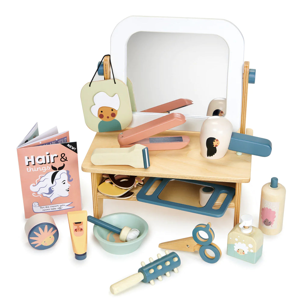 A child's Hair Salon set with a mirror, hair salon tools, beauty products, and accessories, all spread out on a white surface.