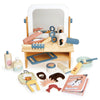 A wooden toy Hair Salon set with a mirror, featuring various pretend hair salon tools, beauty products, and a magazine, all neatly arranged and displayed.