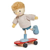 Edward and his Skateboard, a wooden toy figure with blonde hair and a striped shirt balancing on a solid wood skateboard, isolated on a white background.