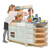 Two young children play together in the La Fiamma Grand Kitchen, pretending to cook with toy food and utensils. This kids kitchen set features shelves, a pizza oven toy, an oven, a sink, and several playful accessories.
