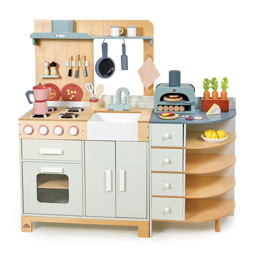 The La Fiamma Grand Kitchen is a charming wooden play kitchen set that includes a stove, oven, sink, hanging utensils, play food, and an adorable pizza oven toy. With shelves for storing toy fruits and vegetables, pastel colors, and rounded edges for safety, this inviting kids kitchen set inspires endless hours of imaginative play.