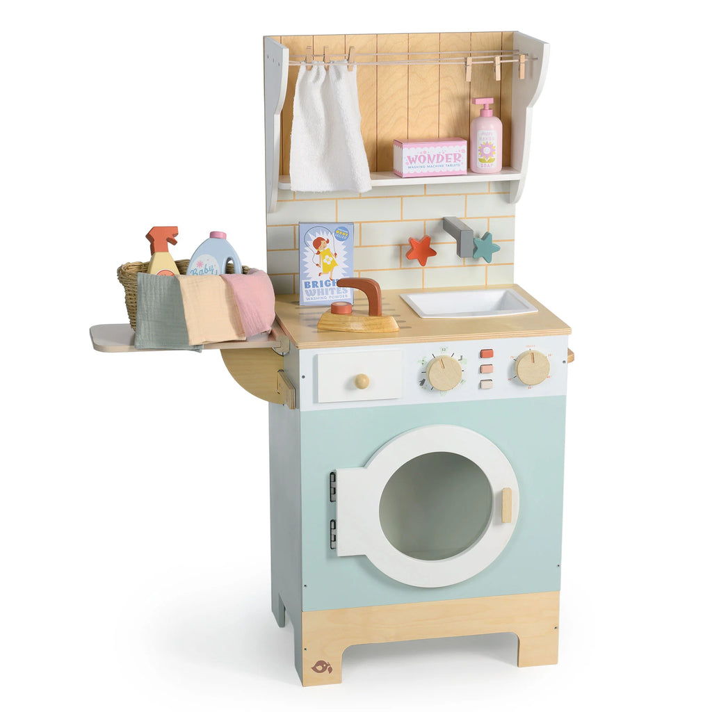 The Wooden Laundrette is a charming wooden toy laundry set that includes a washer, knobs, shelf, towel, cleaning supplies, folded towels, and colorful star hooks. Featuring pastel blue, white, and natural wood tones, it’s perfect for pretend play laundry fun.
