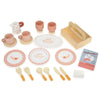 The Kitchen Dresser and Dishwasher wooden toy tea set includes plates, cups, utensils, a small tray, a carton labeled "dishwasher tablets," a butter dish, and a milk pitcher—perfect for any children's play kitchen. All pieces are designed in soft pink, orange, and beige tones to beautifully complement your little one’s Kitchen Dresser and Dishwasher unit.