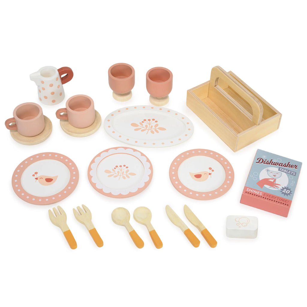 The Kitchen Dresser and Dishwasher wooden toy tea set includes plates, cups, utensils, a small tray, a carton labeled "dishwasher tablets," a butter dish, and a milk pitcher—perfect for any children's play kitchen. All pieces are designed in soft pink, orange, and beige tones to beautifully complement your little one’s Kitchen Dresser and Dishwasher unit.